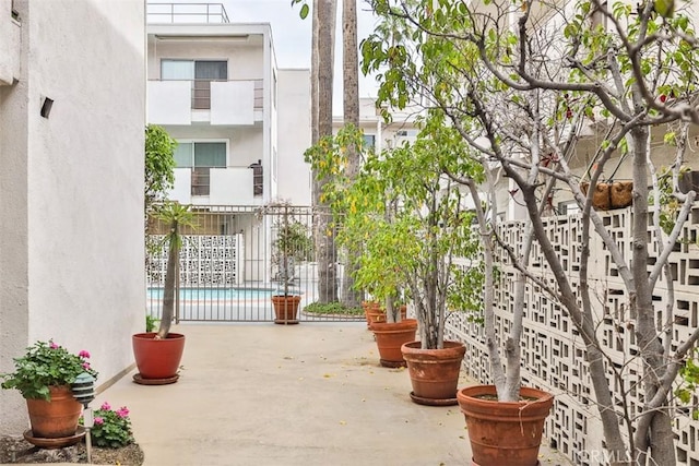 view of patio with fence and a community pool