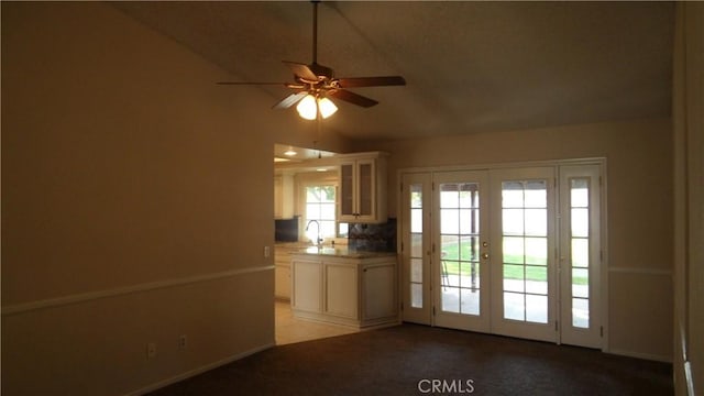 doorway with light colored carpet, lofted ceiling, ceiling fan, french doors, and a sink