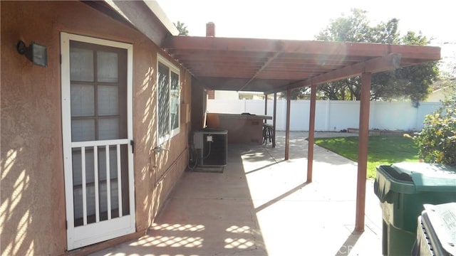 view of patio / terrace featuring fence and central AC unit