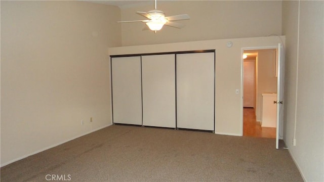 unfurnished bedroom with carpet, a closet, and ceiling fan