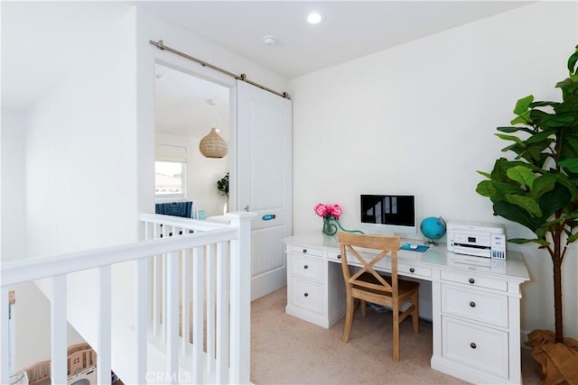 home office with recessed lighting, light carpet, and a barn door