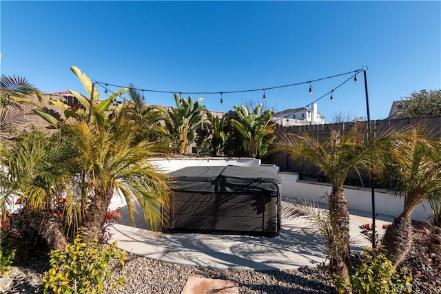 exterior space featuring fence and a hot tub