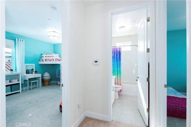 corridor featuring tile patterned flooring, carpet flooring, and baseboards