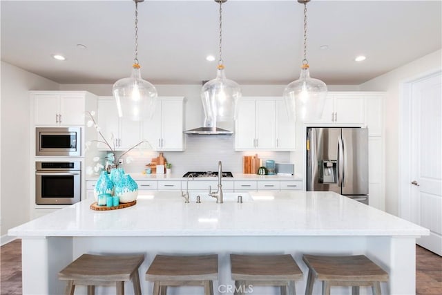 kitchen with stainless steel appliances, white cabinets, and backsplash