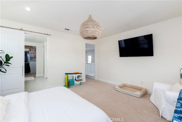 bedroom with carpet, recessed lighting, visible vents, a barn door, and baseboards