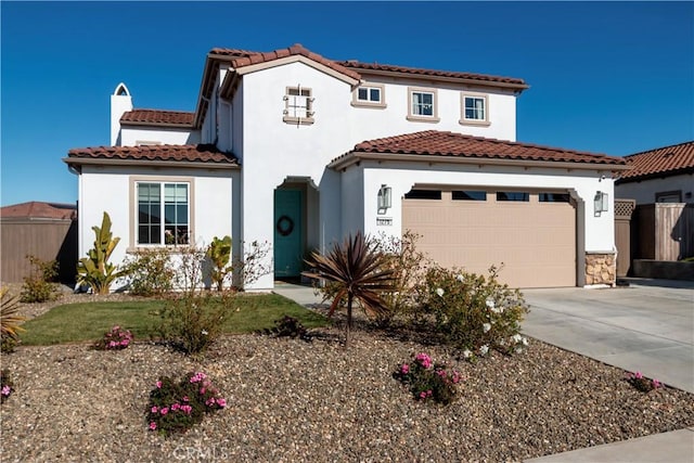 mediterranean / spanish-style house featuring concrete driveway, fence, an attached garage, and stucco siding