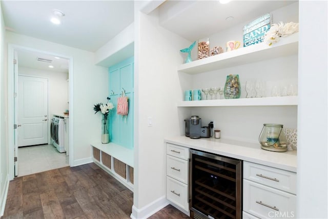 mudroom featuring dark wood-style flooring, a dry bar, beverage cooler, independent washer and dryer, and baseboards