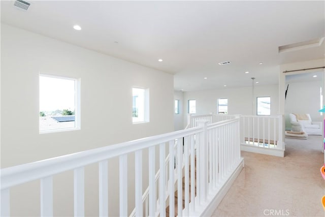 hallway featuring recessed lighting, an upstairs landing, visible vents, and light colored carpet