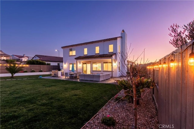 back of property featuring a patio, a fenced backyard, an outdoor hangout area, a yard, and stucco siding