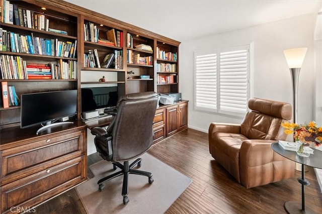 home office with dark wood-type flooring and baseboards