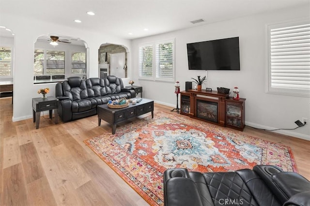 living area with visible vents, arched walkways, baseboards, light wood-type flooring, and recessed lighting