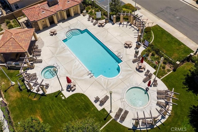 community pool with a patio and a hot tub