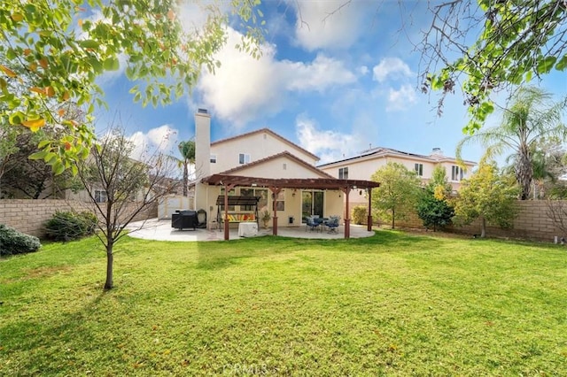 back of property with a yard, a fenced backyard, a chimney, and a patio