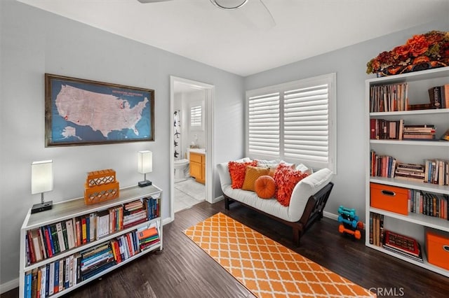 living area with baseboards and wood finished floors