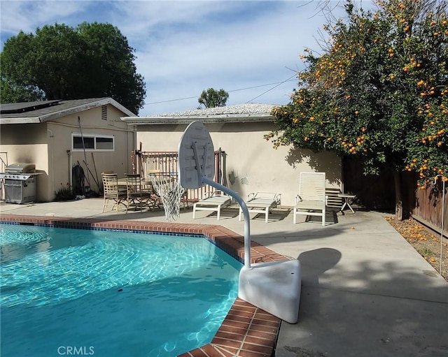 view of pool with a patio, area for grilling, fence, and a fenced in pool