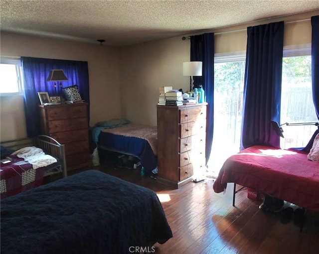 bedroom featuring a textured ceiling and wood finished floors