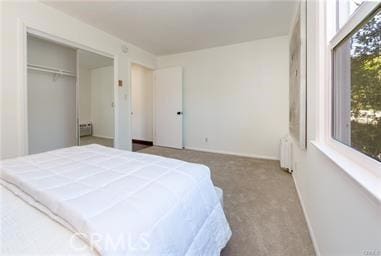 carpeted bedroom with baseboards and radiator