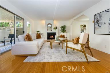 living room featuring a warm lit fireplace and wood finished floors