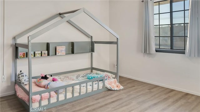 bedroom featuring baseboards and wood finished floors