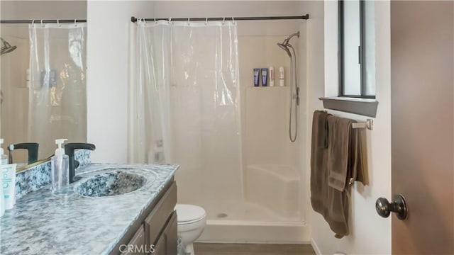 bathroom with curtained shower, vanity, and toilet