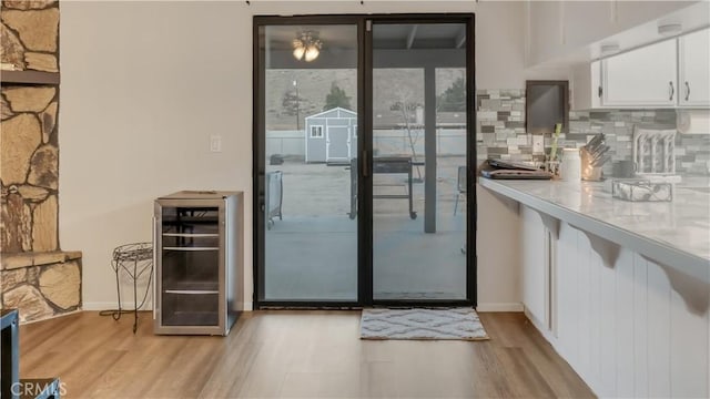 entryway with beverage cooler and light wood-style flooring