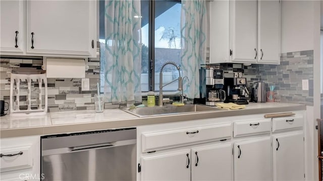 kitchen with a sink, white cabinetry, light countertops, stainless steel dishwasher, and tasteful backsplash