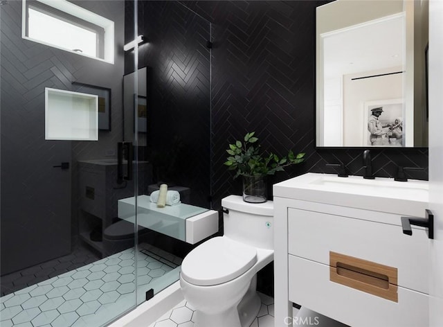 bathroom featuring toilet, vanity, tile walls, a shower stall, and tile patterned floors