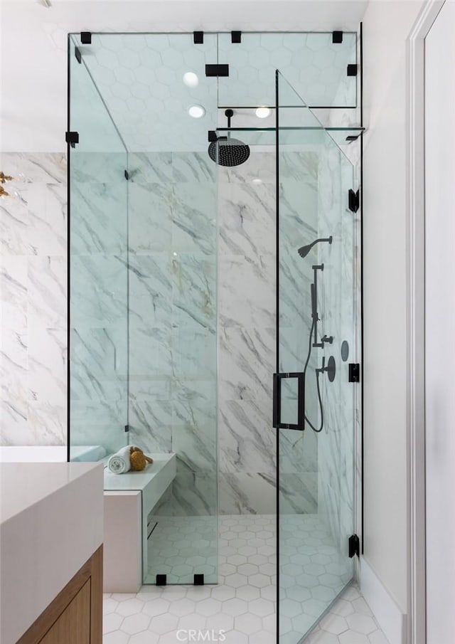 bathroom featuring a marble finish shower and vanity