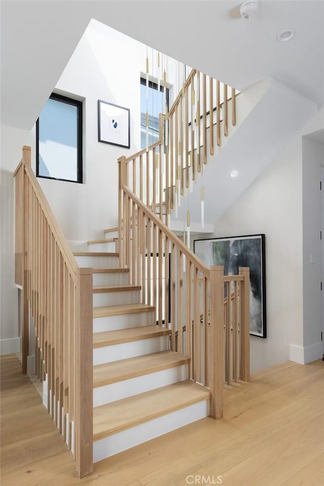 staircase with recessed lighting, baseboards, and wood finished floors