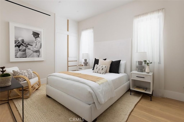 bedroom with light wood-style floors and baseboards