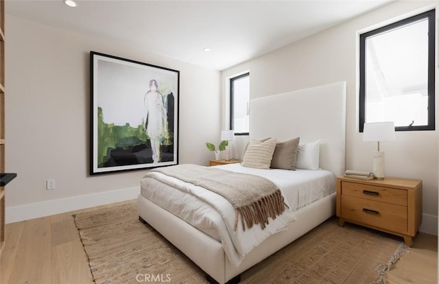 bedroom featuring light wood-style flooring, multiple windows, baseboards, and recessed lighting