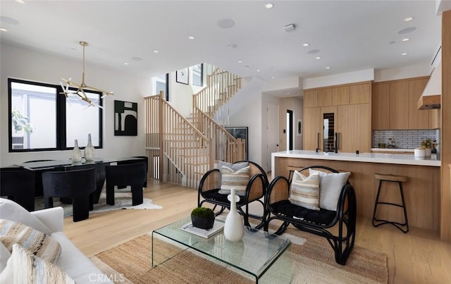 living area with stairway, light wood-type flooring, and recessed lighting