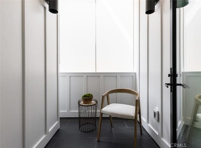 living area featuring dark tile patterned floors and a decorative wall