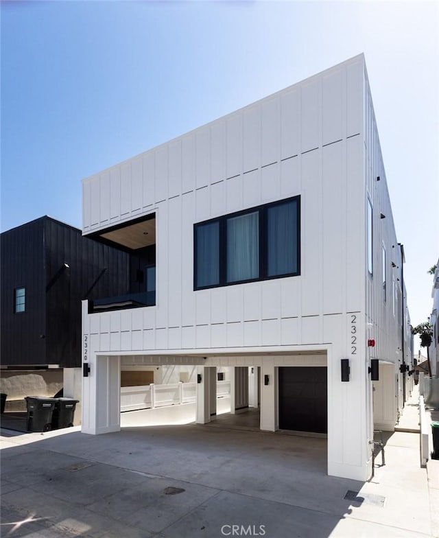 view of front facade with board and batten siding, concrete driveway, and a garage