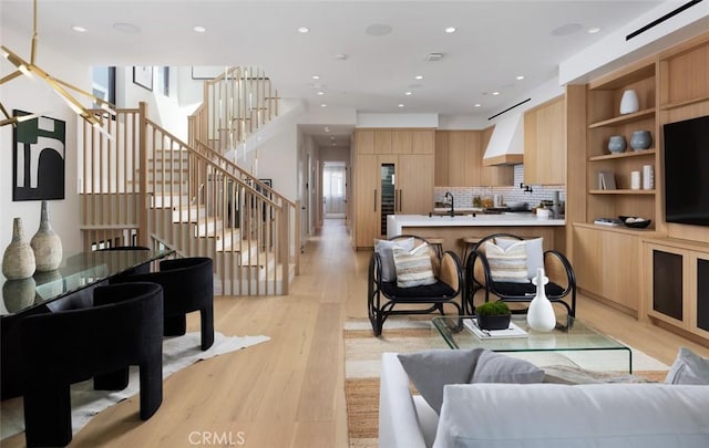 living area featuring recessed lighting, light wood finished floors, and stairs