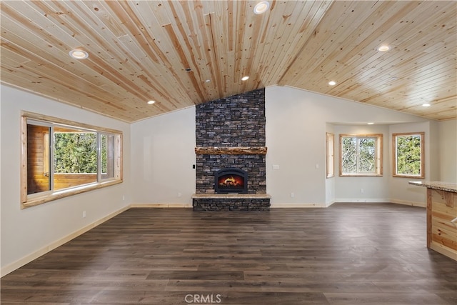 unfurnished living room with lofted ceiling, dark wood-style flooring, a healthy amount of sunlight, and a stone fireplace