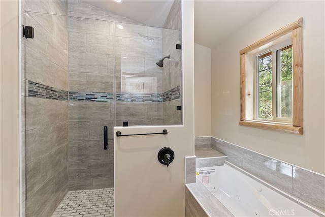 bathroom with vaulted ceiling, a tub with jets, and a shower stall