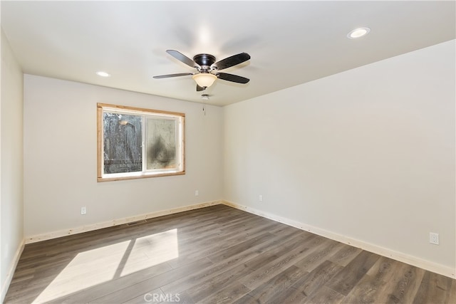 unfurnished room with recessed lighting, visible vents, dark wood finished floors, and baseboards