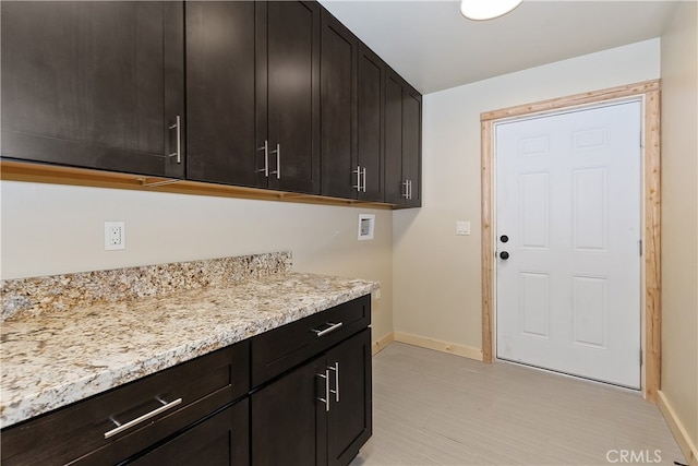 laundry area featuring washer hookup, cabinet space, and baseboards