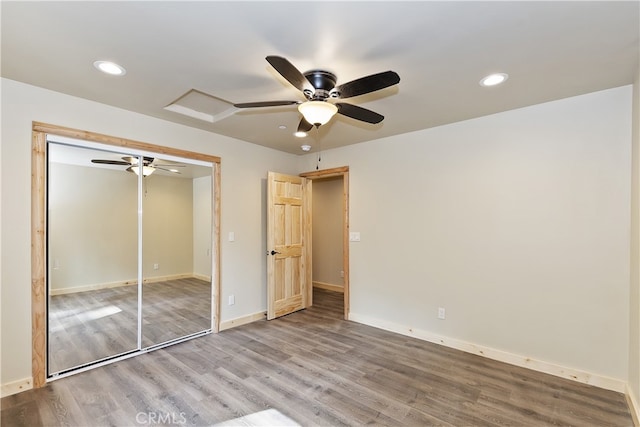 unfurnished bedroom featuring attic access, baseboards, a ceiling fan, wood finished floors, and recessed lighting