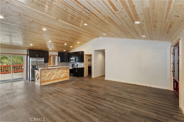 kitchen featuring stainless steel appliances, tasteful backsplash, light countertops, dark wood-type flooring, and open floor plan