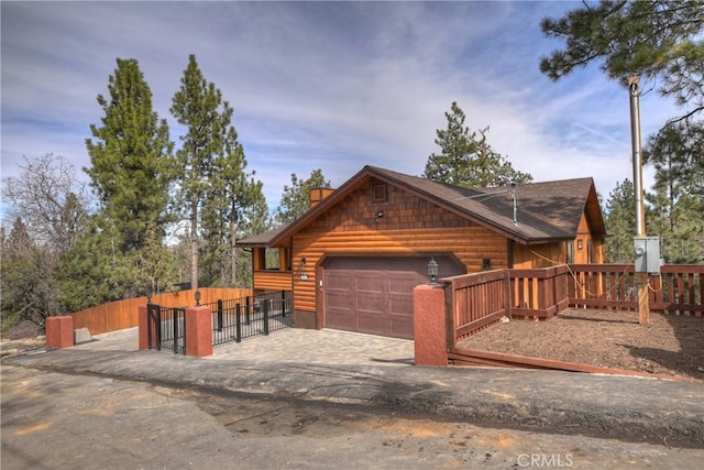 view of front of property with a garage, log veneer siding, fence, and driveway