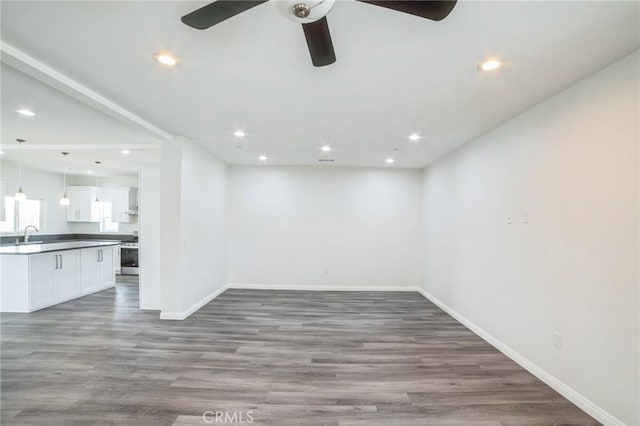 unfurnished room featuring a ceiling fan, baseboards, wood finished floors, and recessed lighting