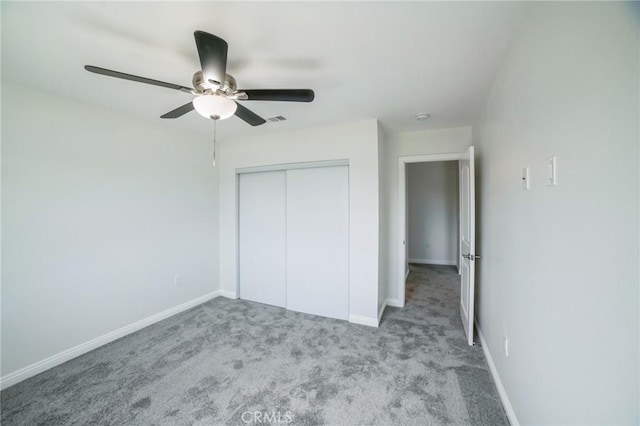 unfurnished bedroom with a closet, carpet, visible vents, and baseboards