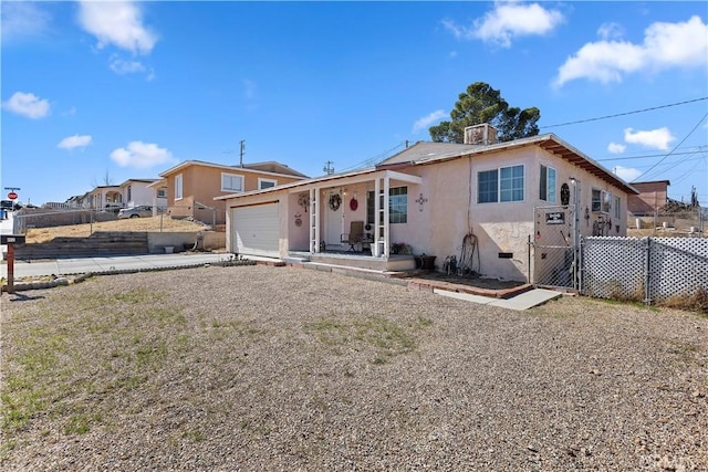 view of front of home featuring an attached garage, fence, and stucco siding