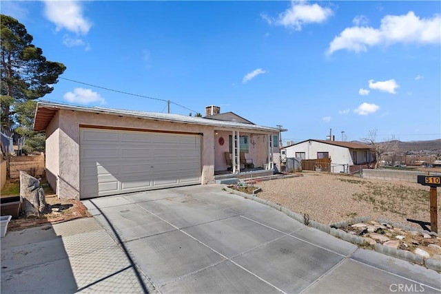 single story home featuring driveway, an attached garage, fence, and stucco siding