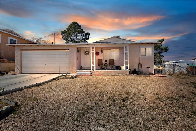 view of front of house with a garage, covered porch, fence, concrete driveway, and stucco siding