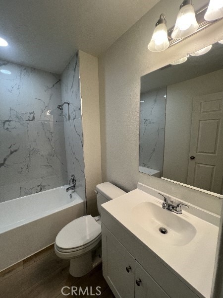 bathroom featuring washtub / shower combination, wood finished floors, vanity, and toilet