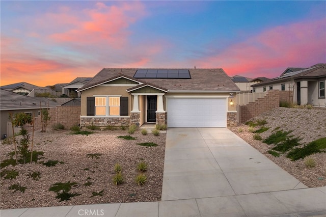 view of front of house with stone siding, fence, concrete driveway, and stucco siding