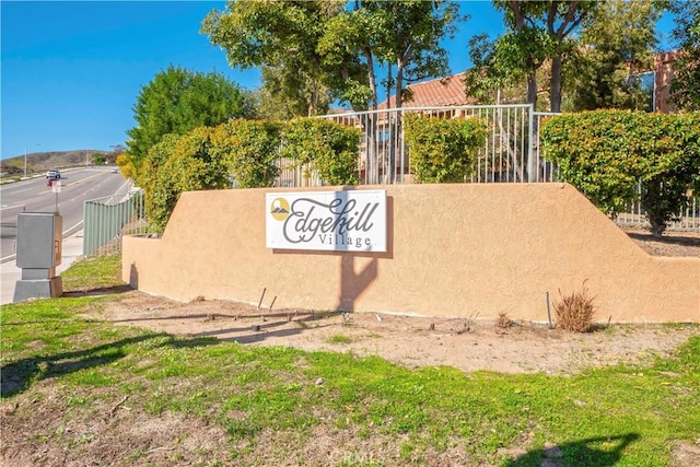 community / neighborhood sign featuring fence